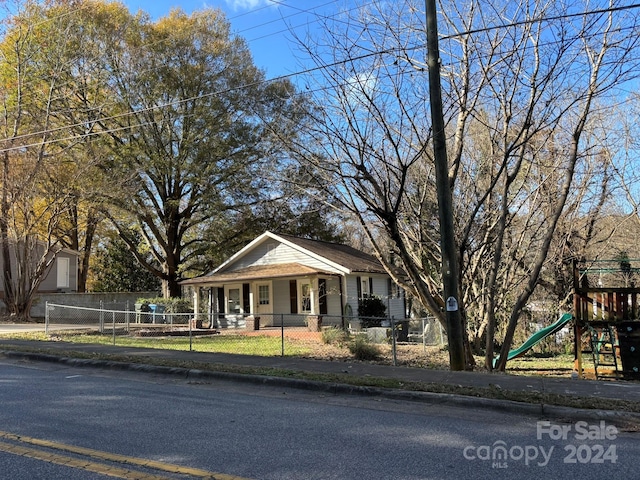 view of front of house with covered porch and a playground