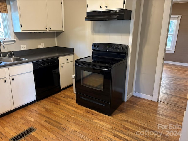 kitchen with sink, white cabinets, black appliances, and light hardwood / wood-style floors