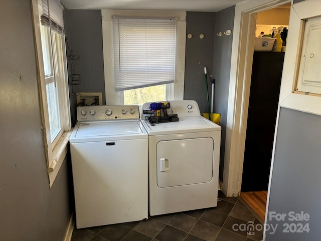 laundry area featuring washer and dryer and dark tile patterned floors