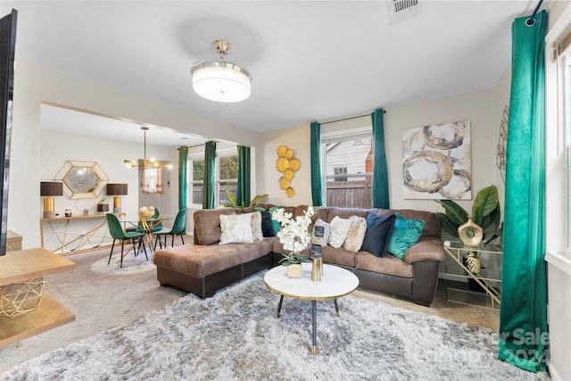 living room with carpet floors and a chandelier