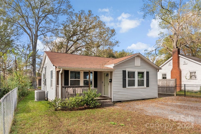 view of front of property with a front lawn, covered porch, and central AC unit