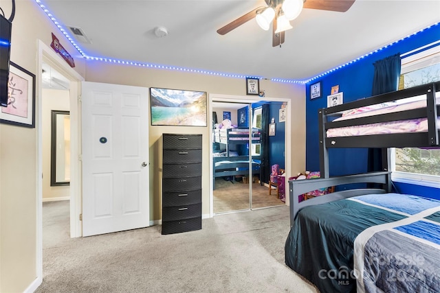 carpeted bedroom featuring ceiling fan and a closet