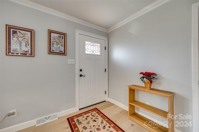 foyer with hardwood / wood-style floors and crown molding