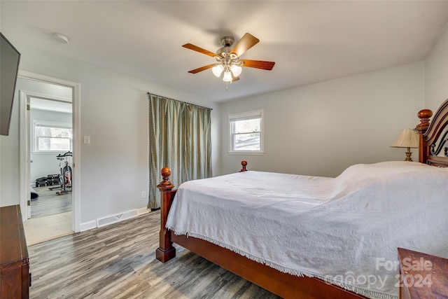 bedroom with multiple windows, ceiling fan, and hardwood / wood-style flooring