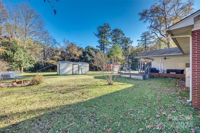 view of yard featuring ceiling fan and a storage shed