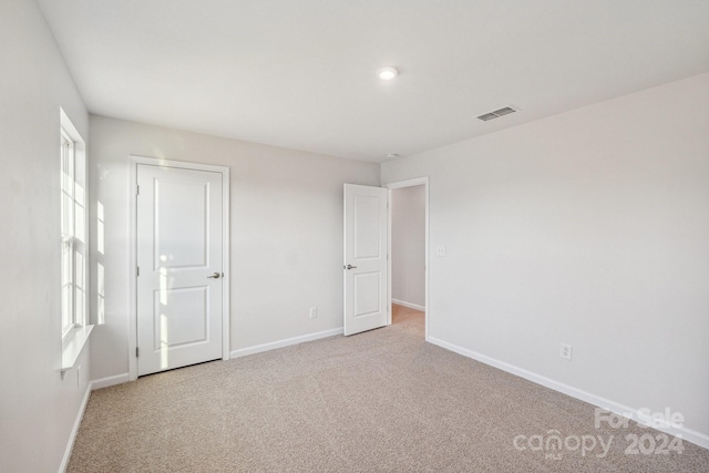 unfurnished room with light carpet and a healthy amount of sunlight