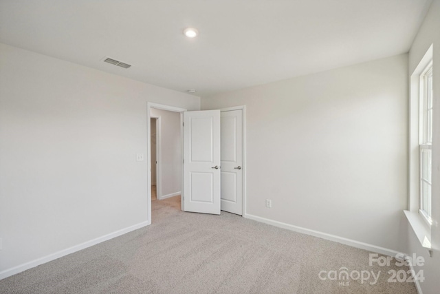 unfurnished bedroom with light colored carpet