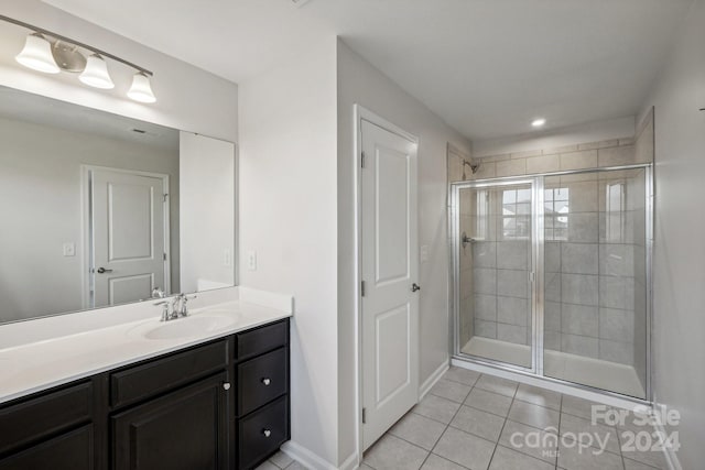 bathroom featuring tile patterned flooring, vanity, and a shower with door