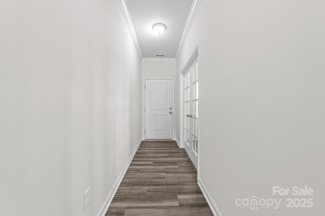 hall featuring dark wood-type flooring and ornamental molding