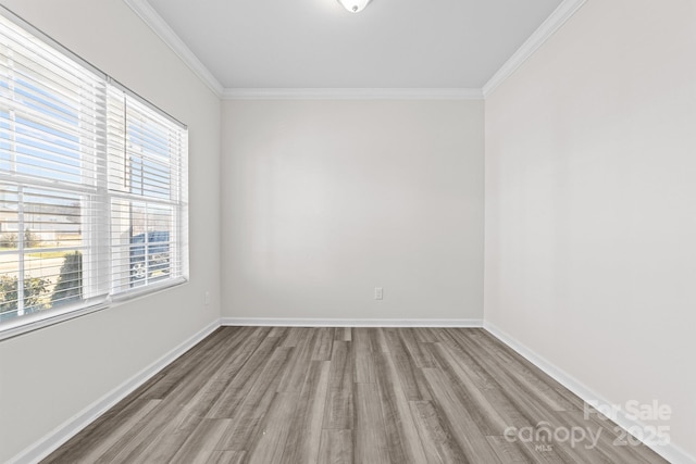 unfurnished room with ornamental molding and light wood-type flooring