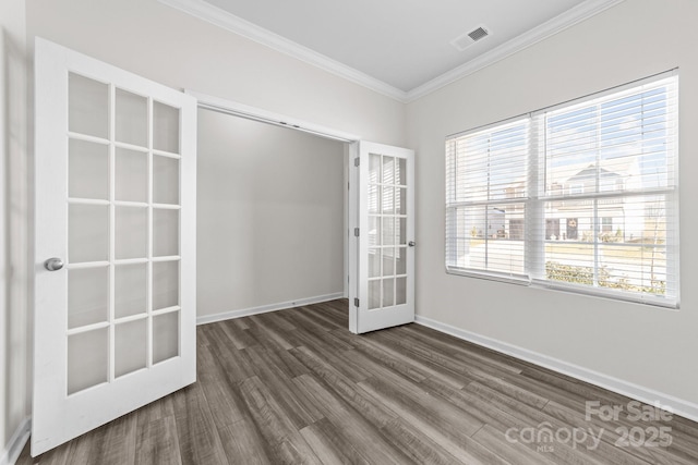 empty room with crown molding, dark wood-type flooring, and french doors