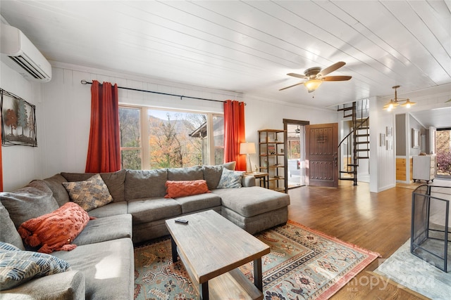 living room featuring ceiling fan, wood-type flooring, a wall unit AC, and wooden ceiling