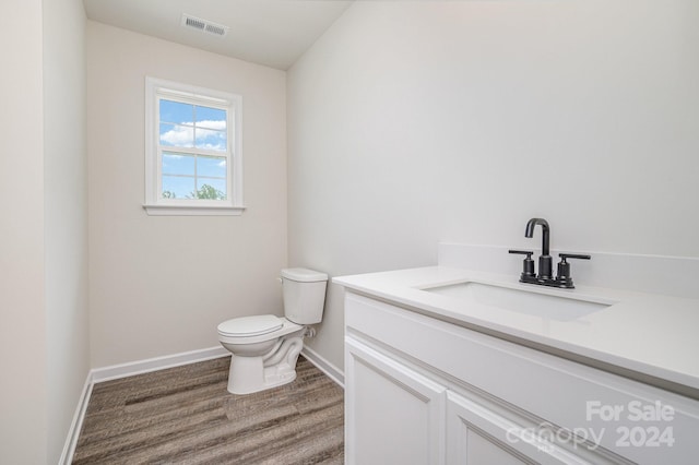 bathroom with vanity, wood-type flooring, and toilet