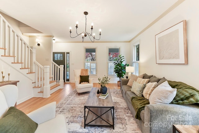 living room featuring hardwood / wood-style flooring, ornamental molding, and a chandelier