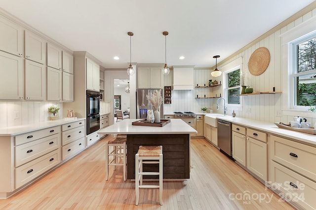 kitchen with pendant lighting, a center island, light hardwood / wood-style floors, and appliances with stainless steel finishes