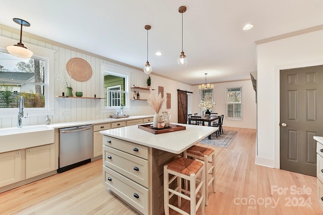 kitchen featuring light hardwood / wood-style floors, stainless steel dishwasher, a kitchen island, and sink