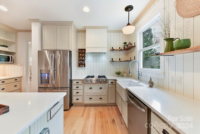 kitchen featuring pendant lighting, premium range hood, appliances with stainless steel finishes, light hardwood / wood-style floors, and white cabinetry