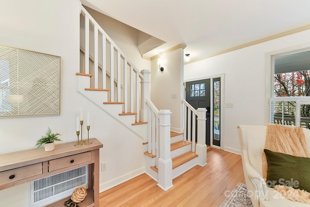 stairs with hardwood / wood-style floors and crown molding