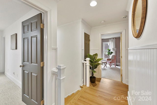 hall featuring light wood-type flooring and crown molding