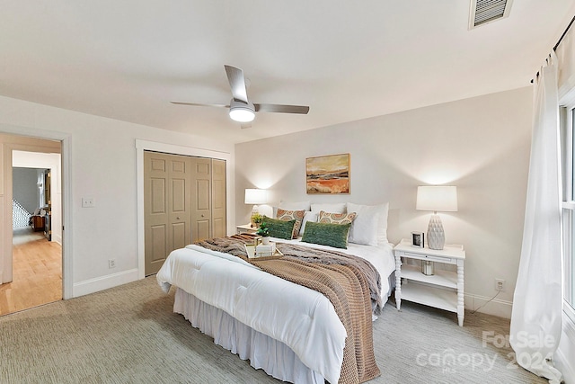 carpeted bedroom featuring ceiling fan and a closet