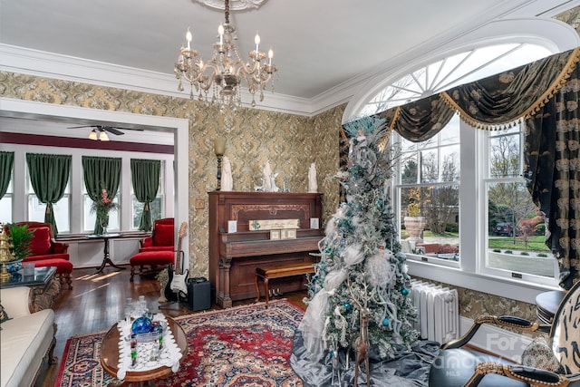 interior space featuring dark hardwood / wood-style floors, a healthy amount of sunlight, crown molding, and ceiling fan with notable chandelier