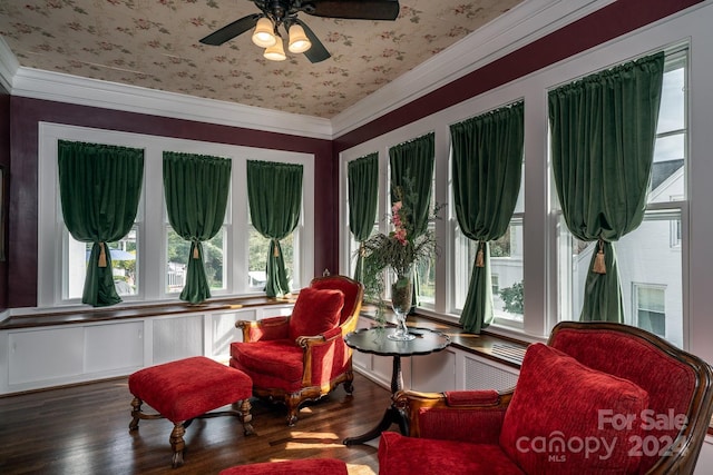 sitting room with hardwood / wood-style floors, ceiling fan, and crown molding