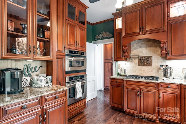 kitchen featuring dark hardwood / wood-style floors, light stone countertops, ornamental molding, tasteful backsplash, and stainless steel appliances