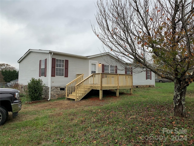 back of house featuring a deck and a lawn