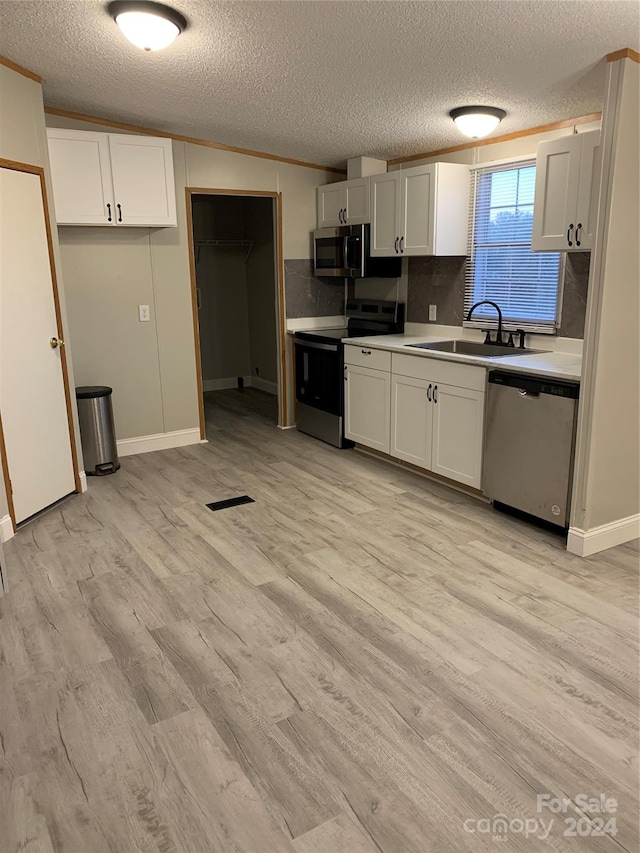 kitchen featuring white cabinets, light wood-type flooring, and stainless steel appliances