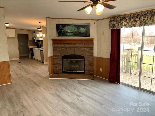 unfurnished living room featuring lofted ceiling, light hardwood / wood-style flooring, ceiling fan, and a stone fireplace