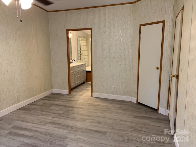 unfurnished bedroom with light hardwood / wood-style floors, ceiling fan, crown molding, and ensuite bathroom