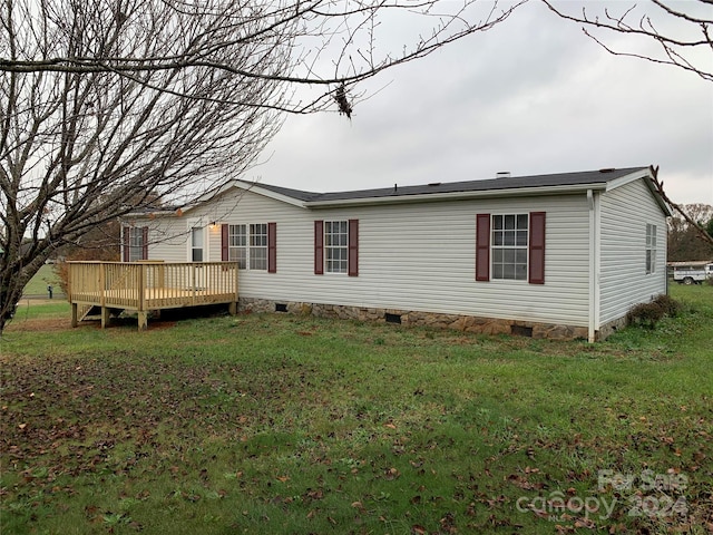 view of side of property featuring a lawn and a deck