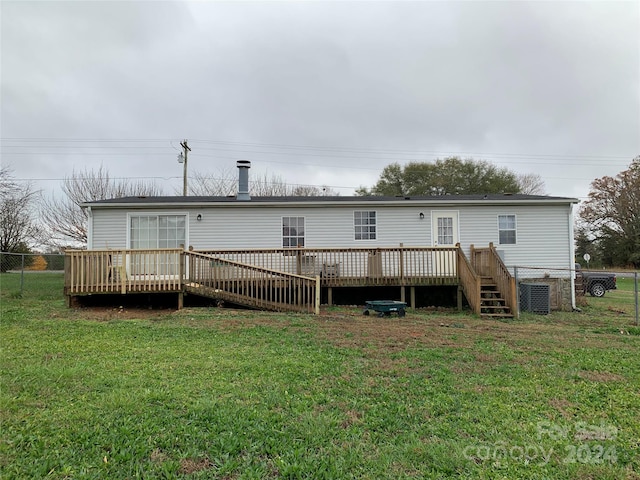 back of house with a wooden deck and a lawn