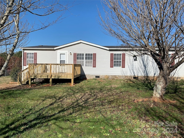 rear view of house featuring a lawn and a deck