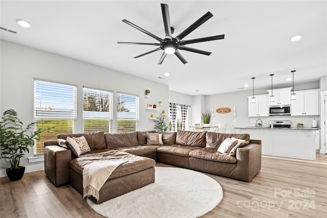 living room featuring light hardwood / wood-style floors and ceiling fan