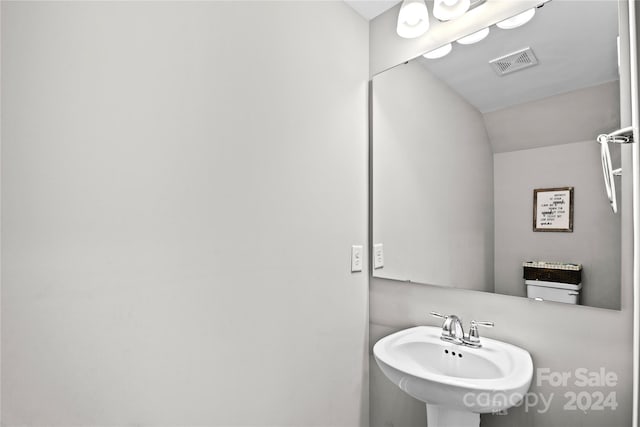 bathroom with lofted ceiling and sink