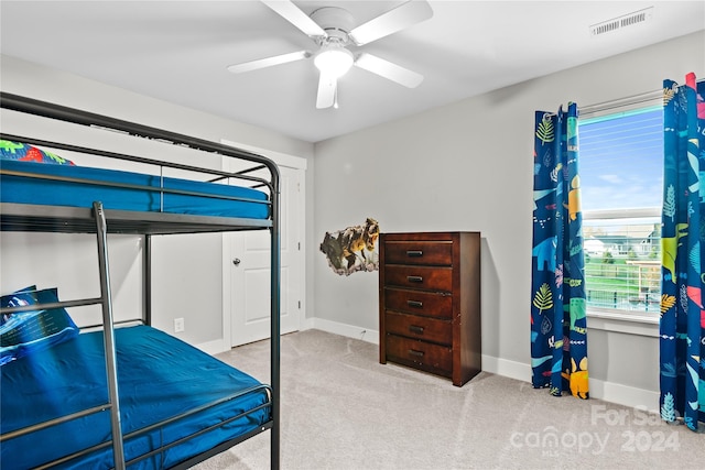 carpeted bedroom with ceiling fan and a closet