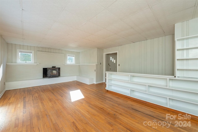 basement with hardwood / wood-style flooring and a wood stove