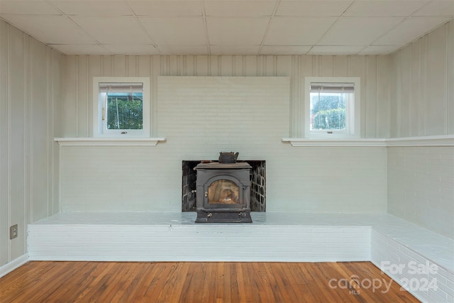 details featuring hardwood / wood-style floors, a wood stove, and wood walls