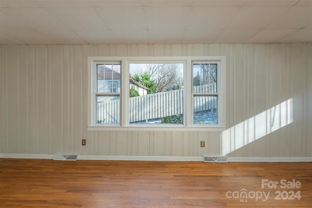 spare room with wood walls and hardwood / wood-style floors