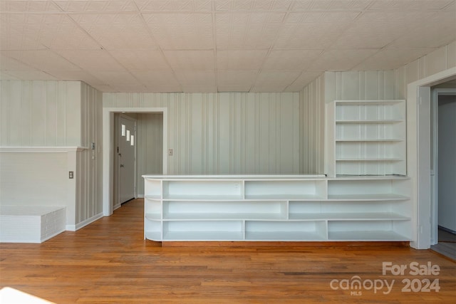 interior space with wood walls and hardwood / wood-style flooring