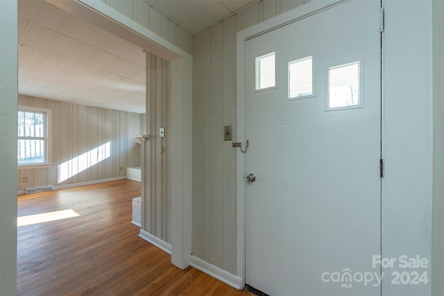 entryway featuring wood-type flooring and wooden walls