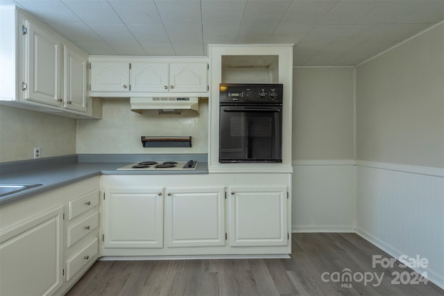 kitchen with black oven, white electric stovetop, white cabinets, exhaust hood, and light wood-type flooring