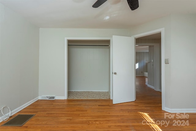 unfurnished bedroom with a closet, ceiling fan, and hardwood / wood-style flooring