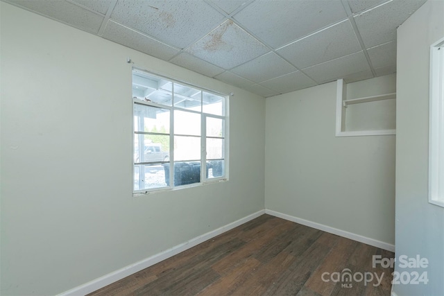 unfurnished room featuring a paneled ceiling and dark hardwood / wood-style floors