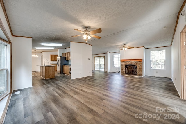 unfurnished living room featuring a fireplace, dark hardwood / wood-style floors, and a textured ceiling