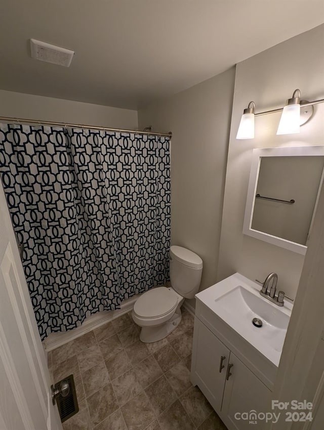 bathroom with tile patterned flooring, vanity, a shower with shower curtain, and toilet