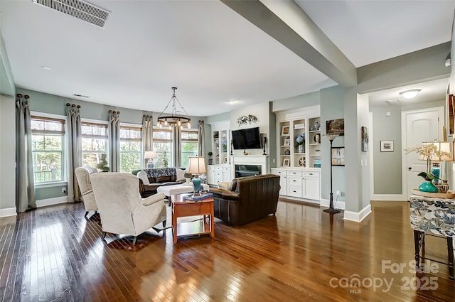 living room with wood-type flooring and built in features