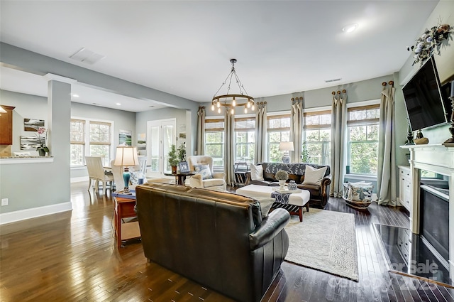 living room with dark hardwood / wood-style floors and a notable chandelier