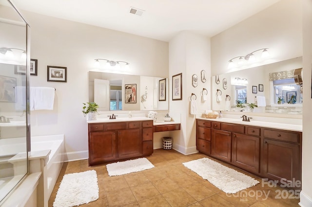 bathroom featuring tile patterned flooring, vanity, and a washtub